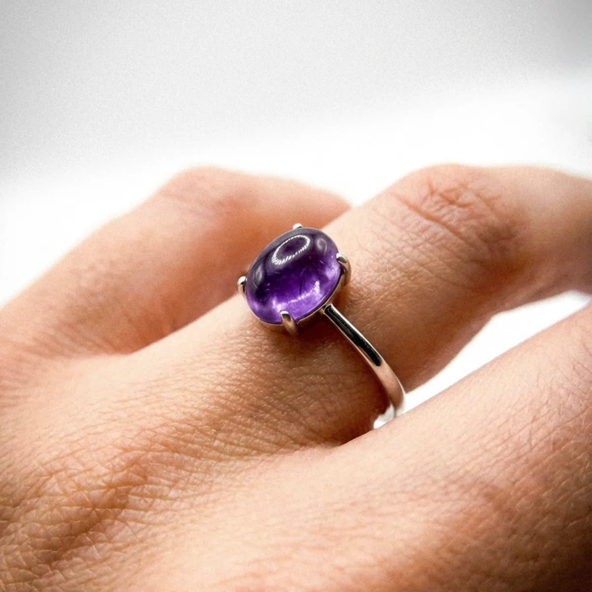 Bague améthyste argent portée à l'annulaire, style spirituel et élégant.