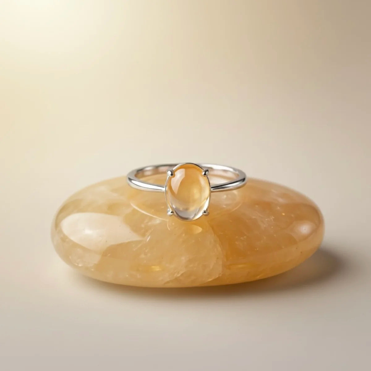 Bague Aura Solaire posée sur un galet de citrine, ambiance lithothérapie et énergie.