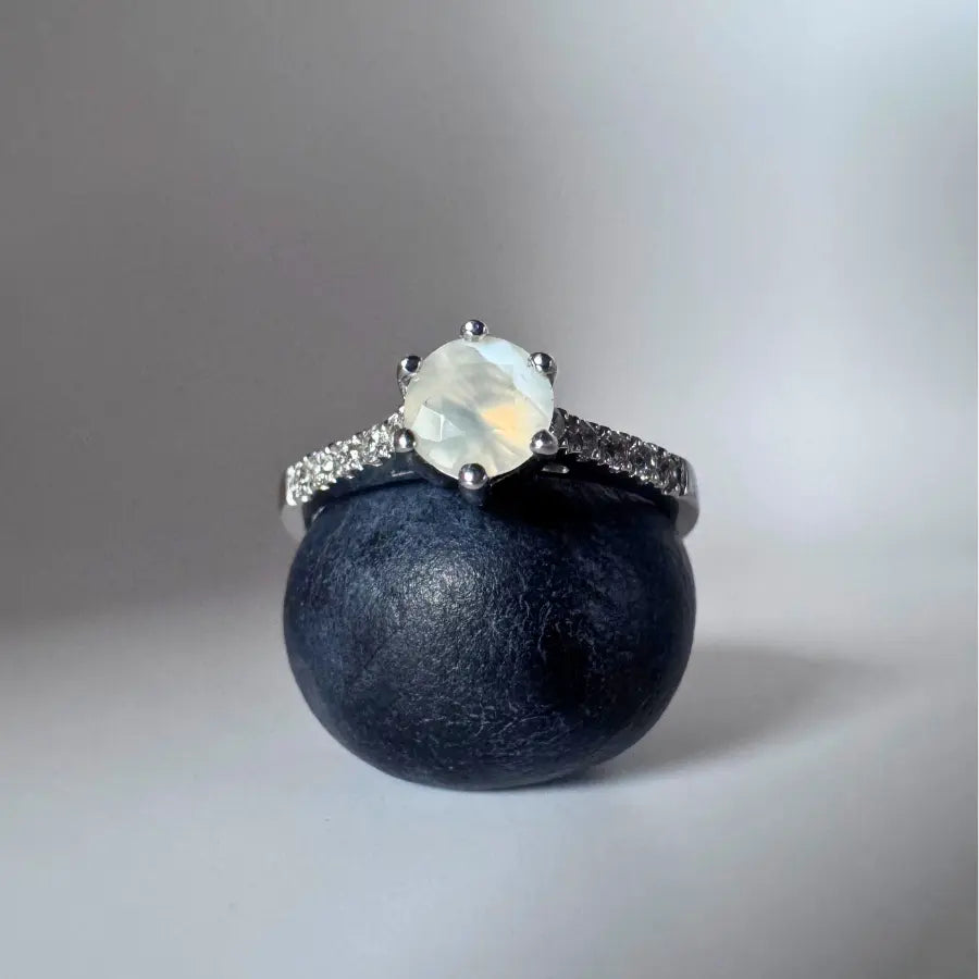 bague en pierre de lune présentée sur une myrtille