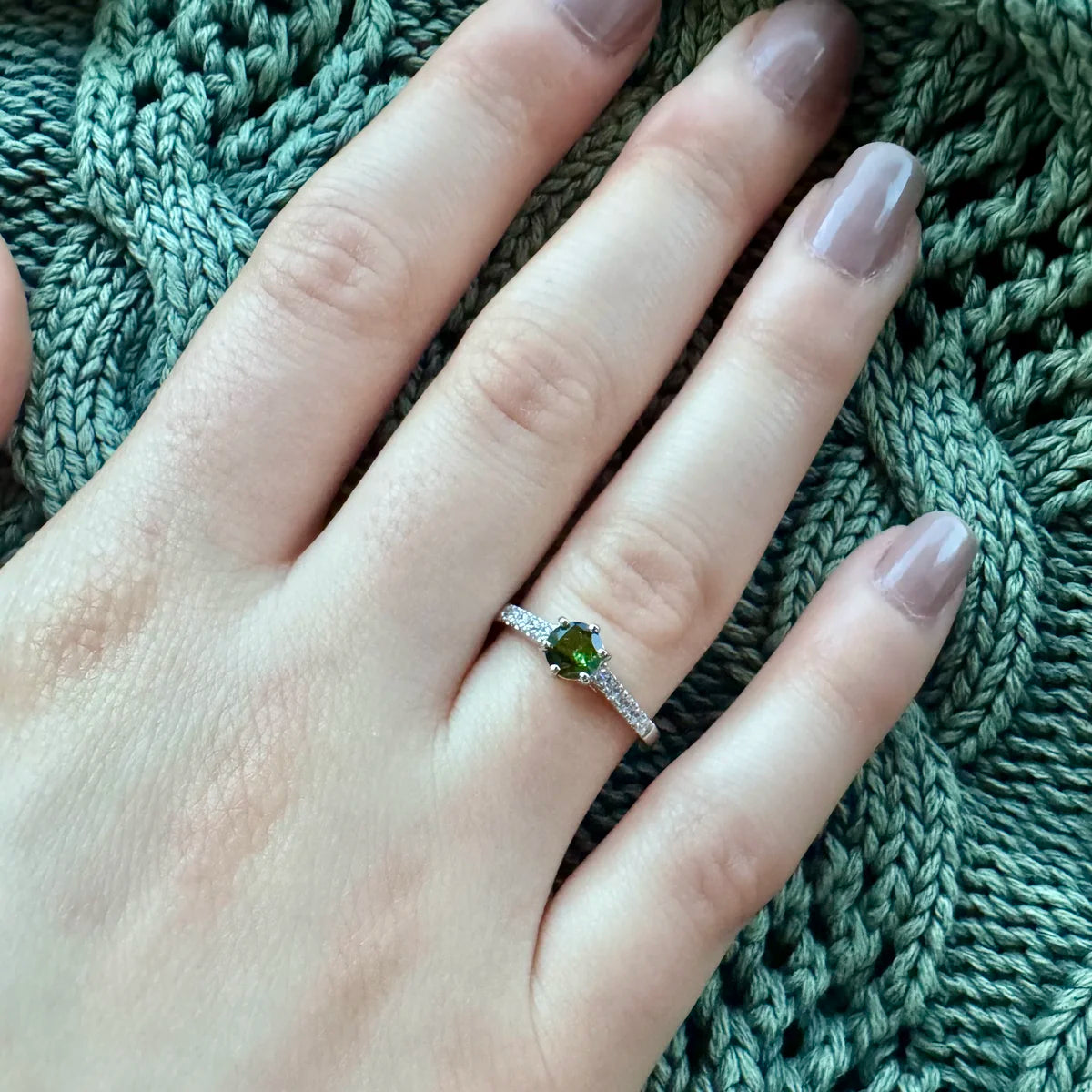 Bague solitaire fine avec Tourmaline verte portée à l'annulaire, élégance naturelle et discrète.
