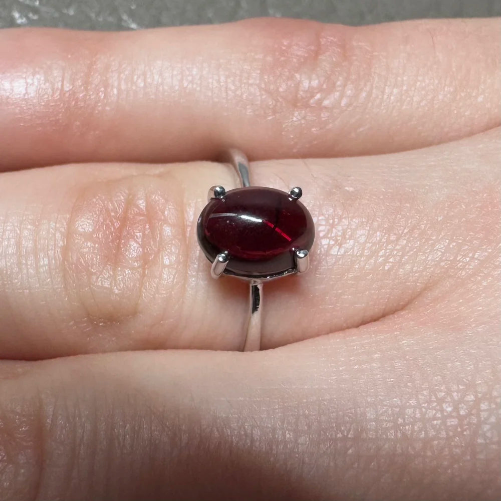 Détail de la bague argent et grenat sous la lumière, révélant sa couleur rouge sang.