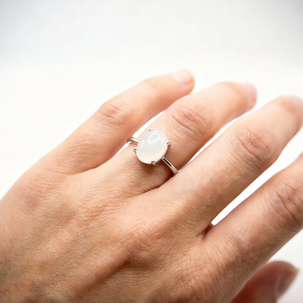 Bague argent pierre de lune portée à l'annulaire, style minimaliste et spirituel pour femme.