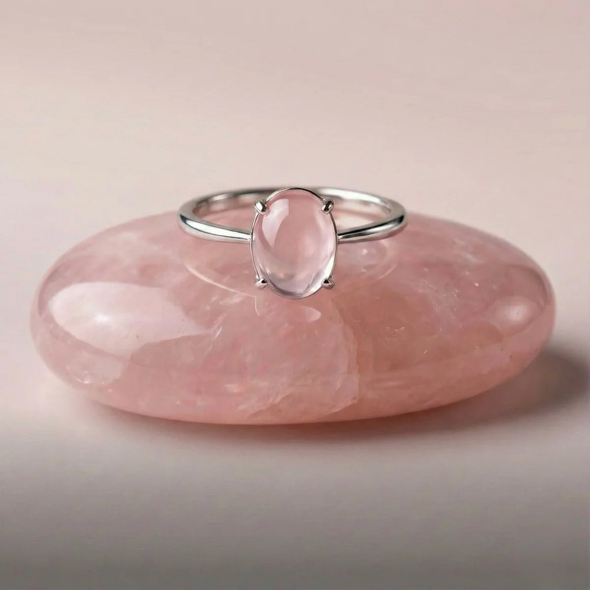 Bague Aura Rose posée sur une pierre quartz rose, symbole amour inconditionnel.