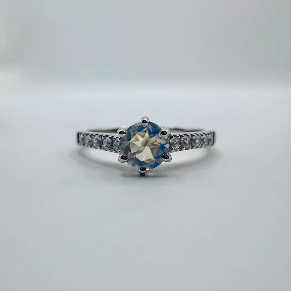 Bague solitaire Pierre de Lune véritable sur monture argent, aux reflets bleus célestes.