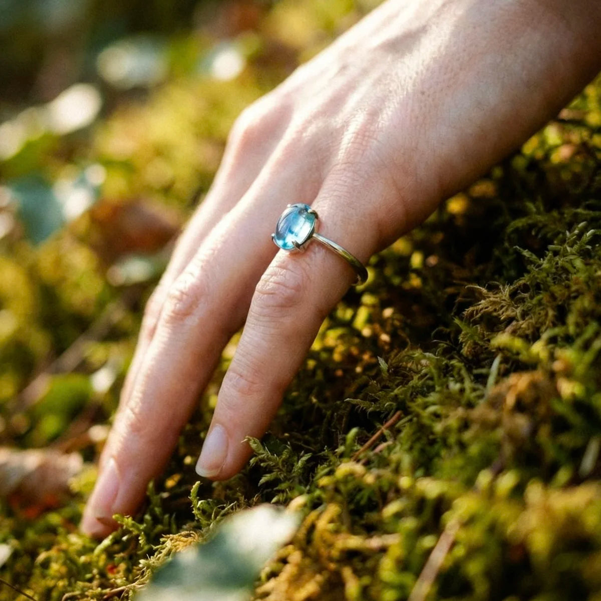 Bague topaze bleue argent portée à l'auriculaire, style doux et apaisant.