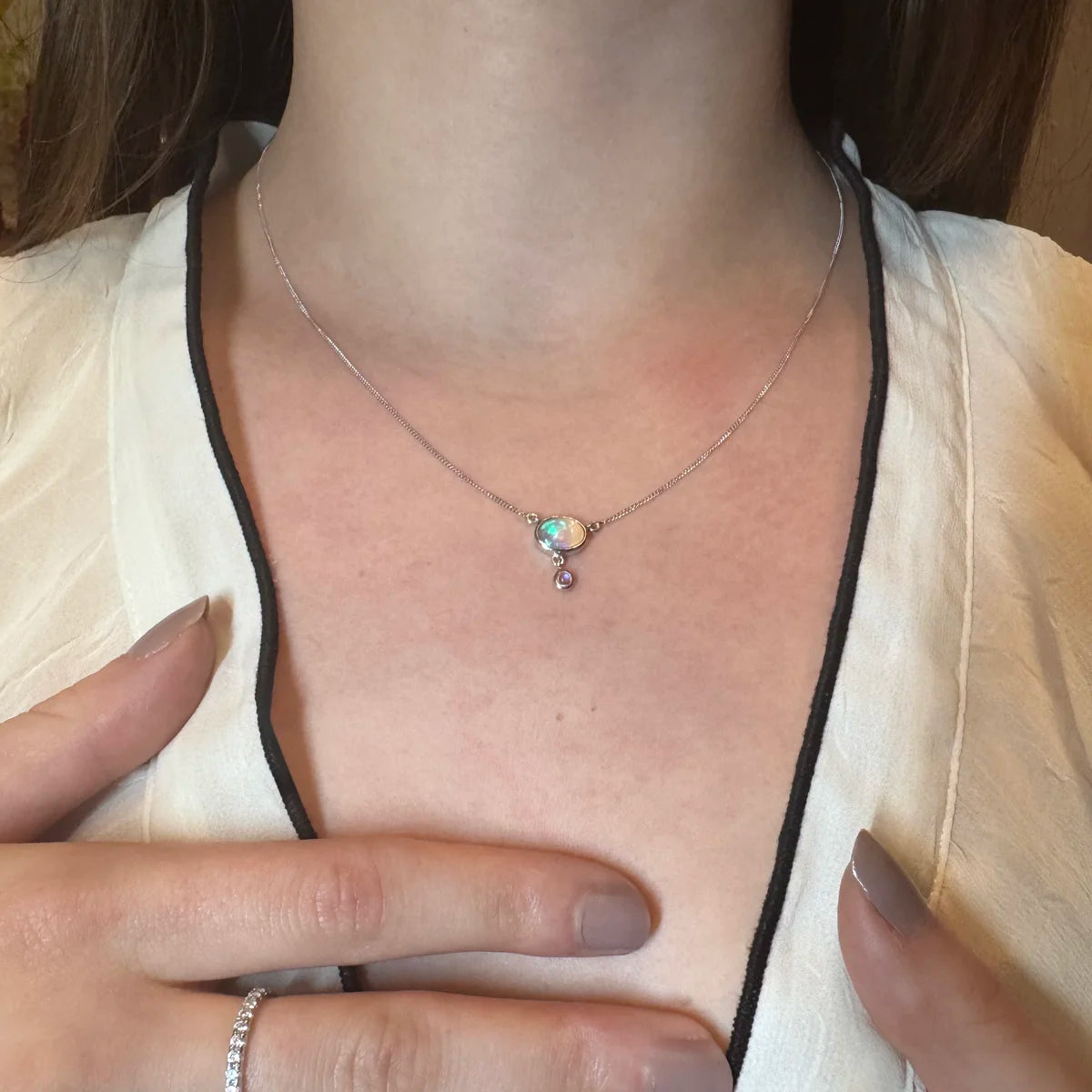 Pendentif opale collier porté autour du cou, sur chaîne fine en argent massif.