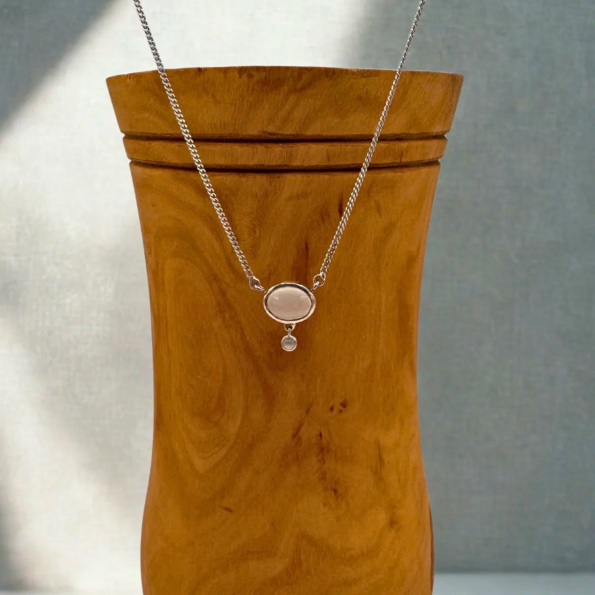 Détail du cabochon de pierre de lune laiteuse et de sa perle inférieure, argent rhodié.