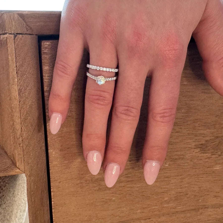 Duo de bagues en argent : Alliance éternité et solitaire portés ensemble pour une parure élégante et scintillante.