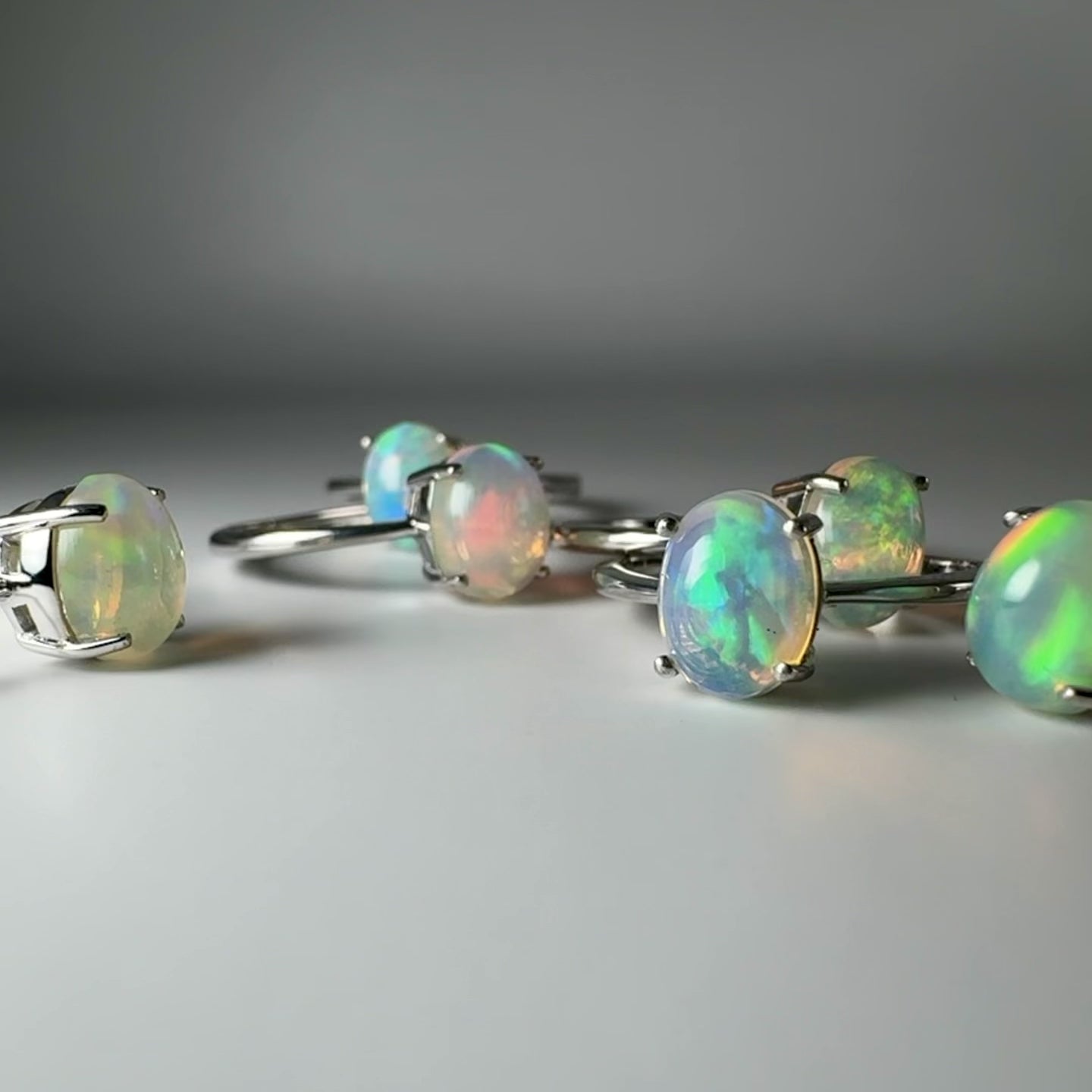 Vidéo montrant le jeu de lumière et l'iridescence changeante des bagues en opale naturelle Séléne Céleste.
